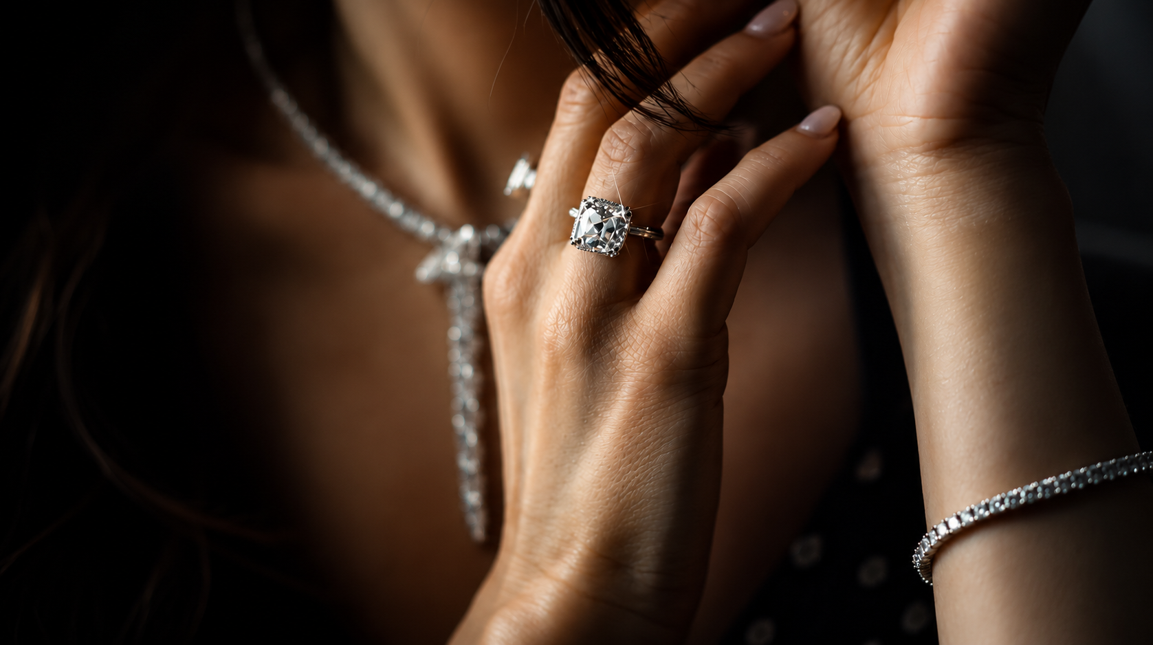 A woman wearing a cushion-halo diamond ring, tennis necklace and tennis bracelet by Diamond Bros & Co.