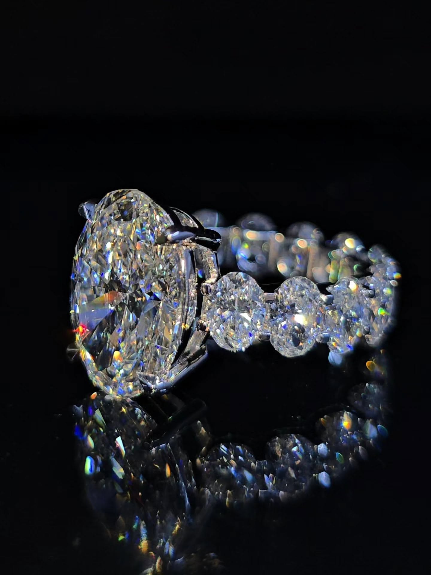 Oval diamond ring with tapered side stones in platinum