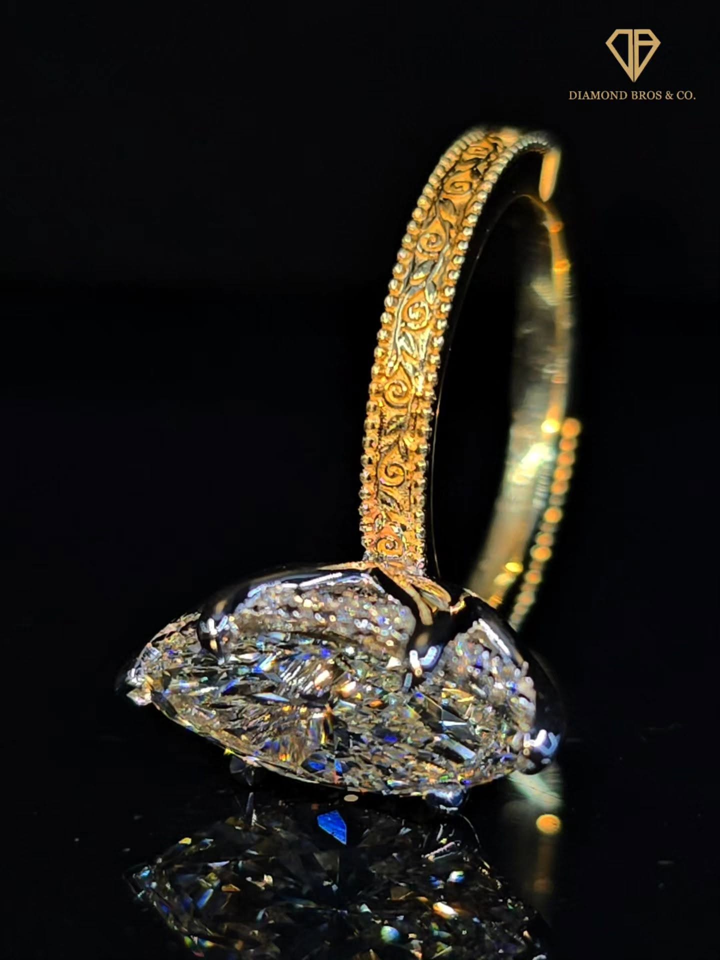 Marquise diamond ring with hand-engraved yellow gold band
