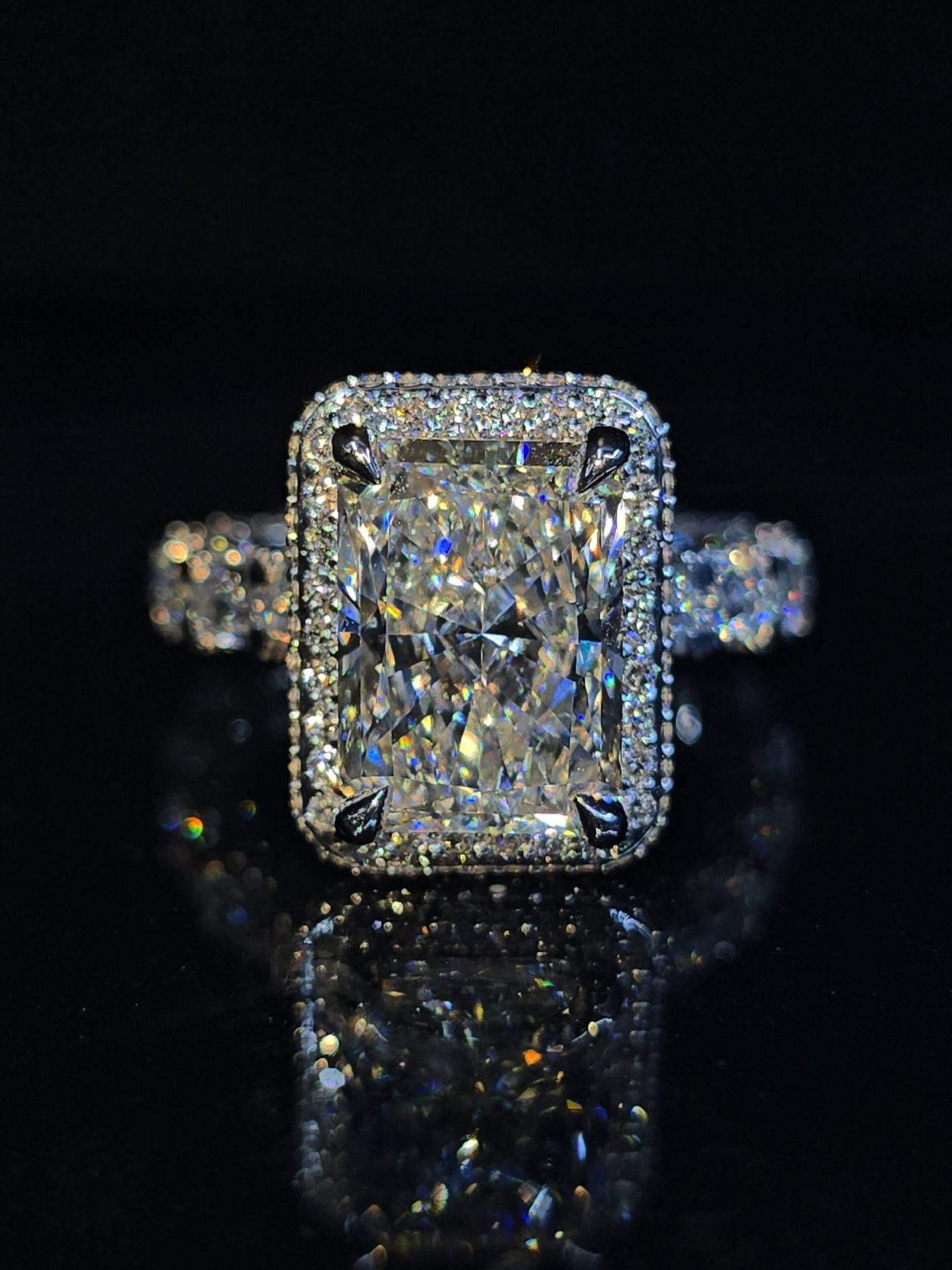 a radiant cut diamond engagement ring with a pavé halo setting